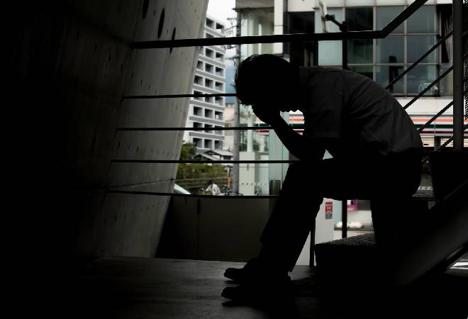 暗がりで悩む男性。